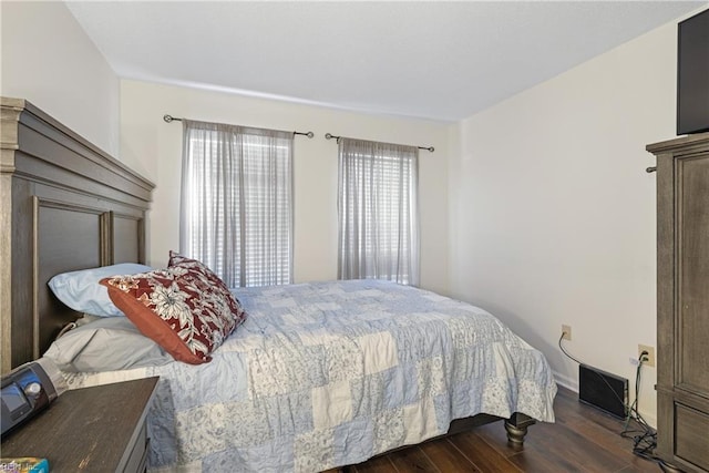 bedroom featuring multiple windows and dark hardwood / wood-style floors