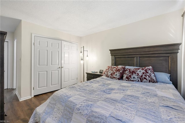 bedroom featuring a textured ceiling, dark wood-type flooring, and a closet