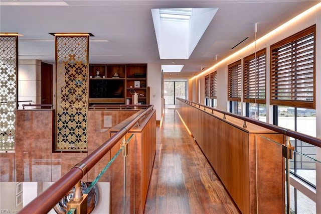 corridor featuring a skylight, hardwood / wood-style floors, and plenty of natural light