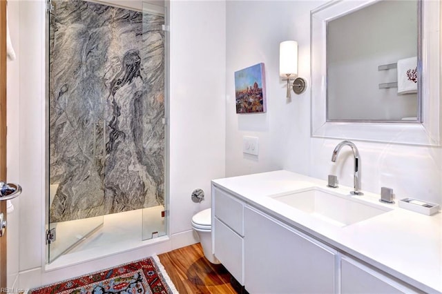 bathroom with toilet, a shower with door, vanity, and hardwood / wood-style floors