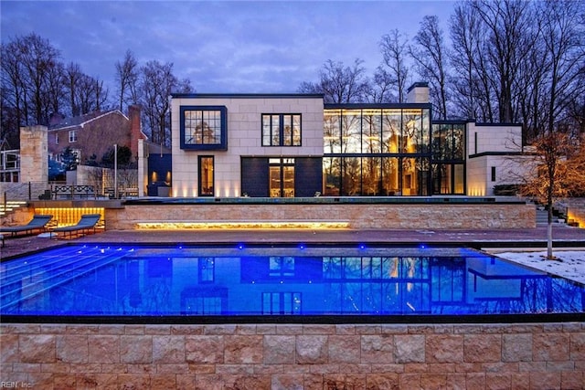 pool at dusk featuring a patio area