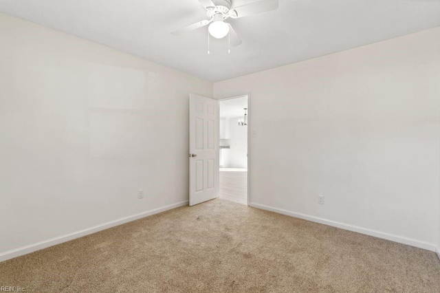 spare room with ceiling fan and light colored carpet