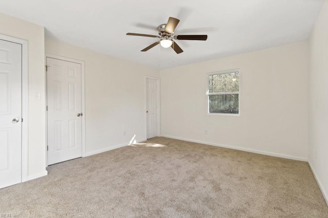 carpeted spare room featuring ceiling fan