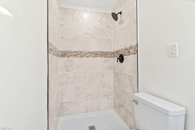 bathroom with toilet and tiled shower