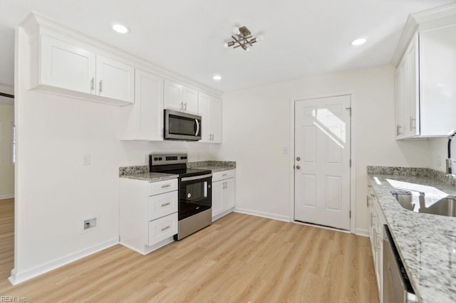 kitchen featuring sink, white cabinetry, light stone countertops, and appliances with stainless steel finishes