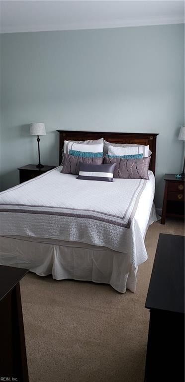 bedroom with carpet floors and crown molding