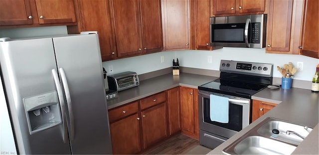 kitchen featuring sink, stainless steel appliances, and dark wood-type flooring