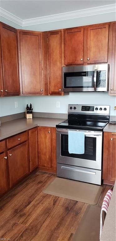 kitchen featuring stainless steel appliances, crown molding, and dark hardwood / wood-style floors