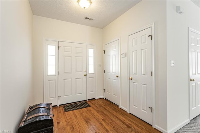 foyer featuring a textured ceiling and wood-type flooring