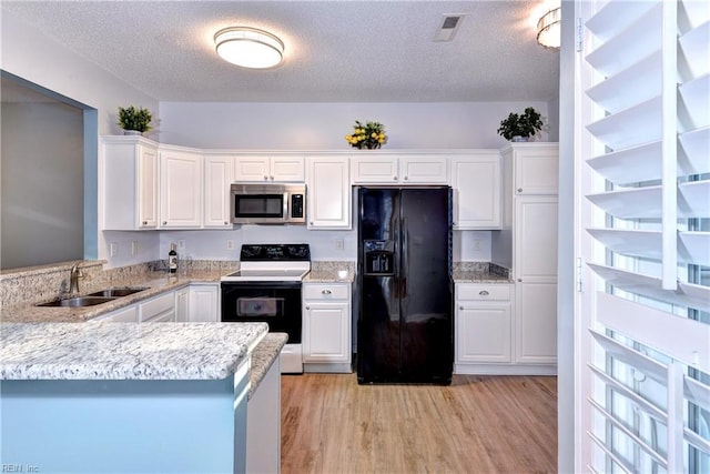 kitchen with kitchen peninsula, black refrigerator with ice dispenser, electric range oven, white cabinets, and sink