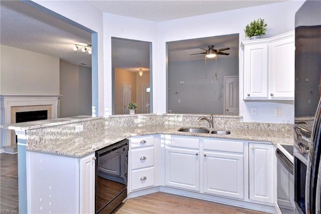 kitchen with white cabinetry, kitchen peninsula, ceiling fan, light stone countertops, and black appliances