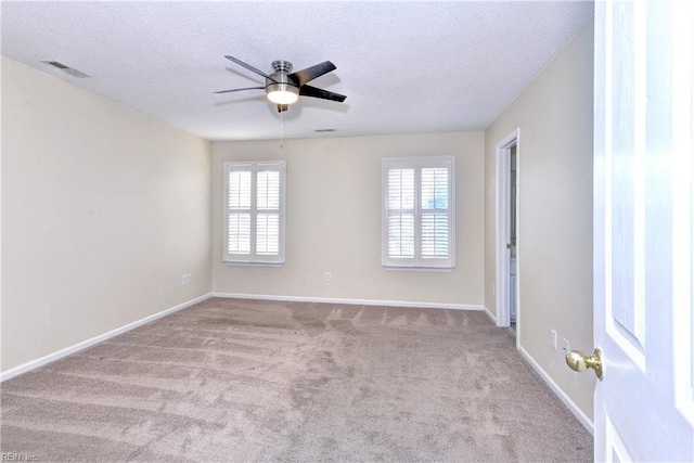 carpeted empty room with a textured ceiling and ceiling fan