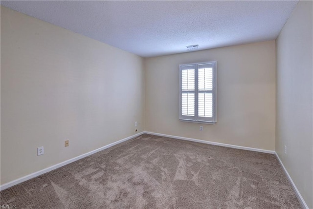 carpeted empty room featuring a textured ceiling