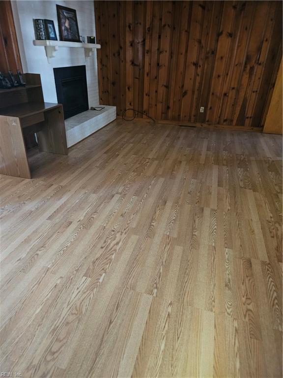 unfurnished living room with a fireplace and light wood-type flooring