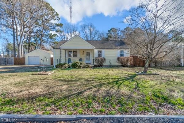 ranch-style home with a front lawn, a garage, covered porch, and an outdoor structure