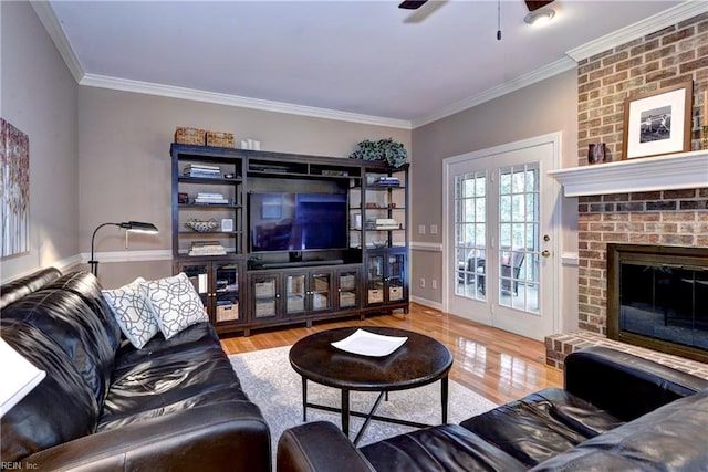 living room featuring ceiling fan, a brick fireplace, crown molding, and hardwood / wood-style flooring