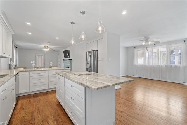 kitchen with white cabinets, appliances with stainless steel finishes, and a center island