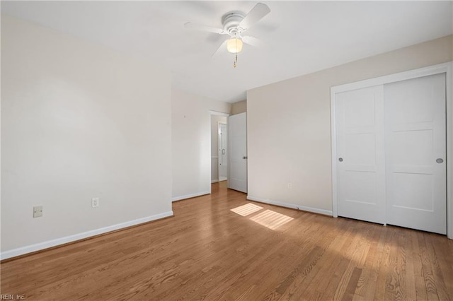 unfurnished bedroom featuring ceiling fan, light hardwood / wood-style floors, and a closet