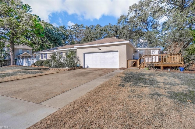 ranch-style house featuring a front lawn, a wooden deck, and a garage