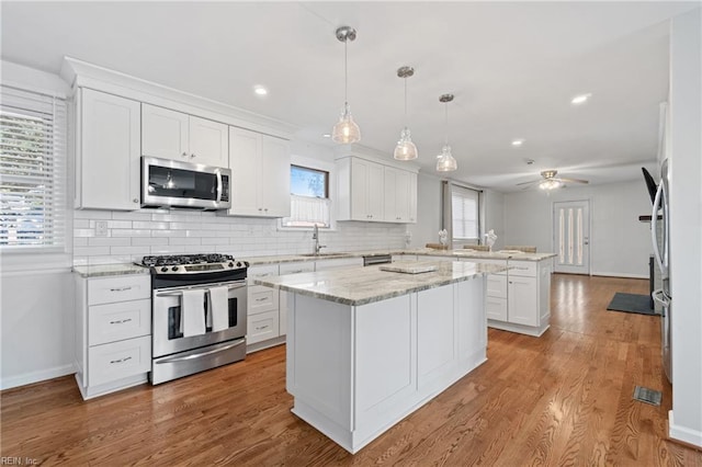 kitchen with ceiling fan, appliances with stainless steel finishes, white cabinets, and sink