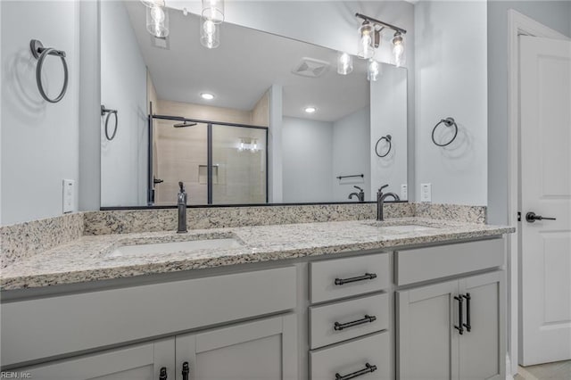 bathroom with a shower with door and vanity