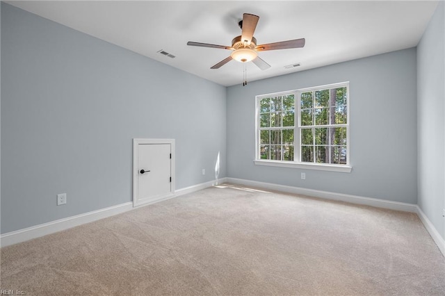 empty room featuring ceiling fan and light carpet