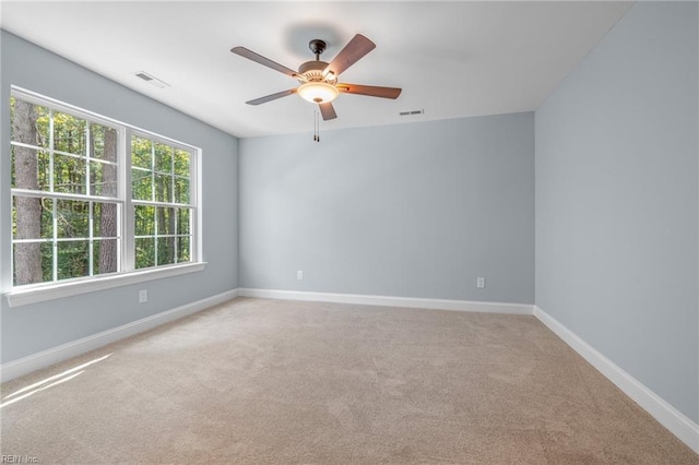 empty room with ceiling fan and light carpet