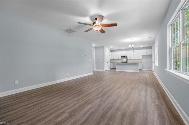 unfurnished living room featuring ceiling fan and dark wood-type flooring