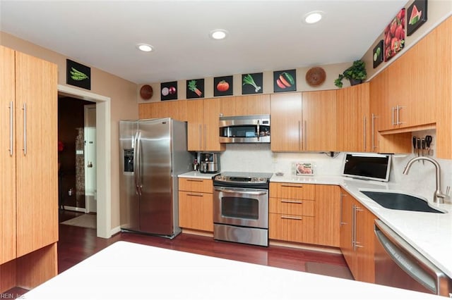 kitchen with appliances with stainless steel finishes, dark hardwood / wood-style floors, tasteful backsplash, and sink