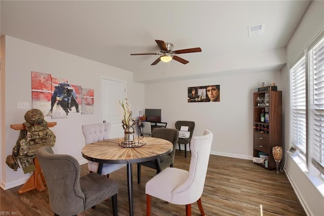 dining area with ceiling fan and dark wood-type flooring