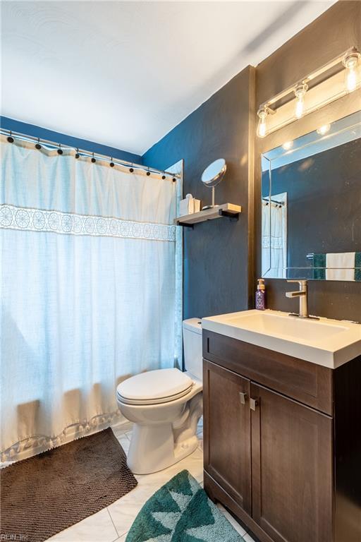 bathroom with toilet, tile patterned flooring, and vanity