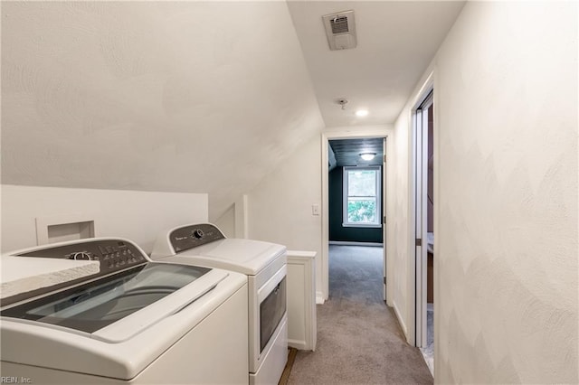 washroom with washer and clothes dryer and light colored carpet