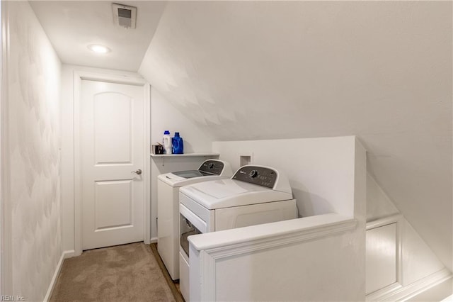 laundry room featuring washing machine and dryer and light colored carpet