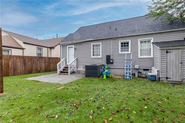 rear view of house featuring a yard, cooling unit, and a patio area