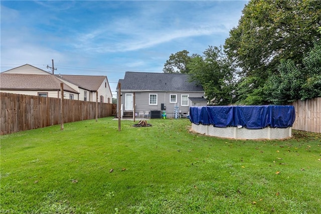 view of yard featuring central AC unit and a covered pool