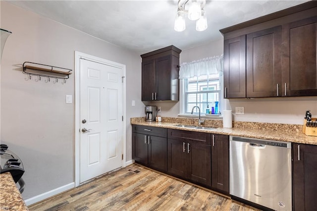 kitchen featuring sink, dark brown cabinets, dishwasher, and light stone counters