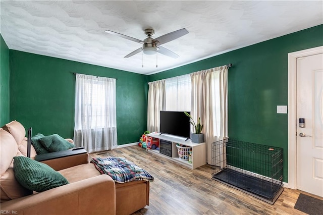 living room featuring a healthy amount of sunlight, ceiling fan, and wood-type flooring