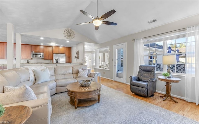 living room featuring vaulted ceiling, light wood-type flooring, and ceiling fan