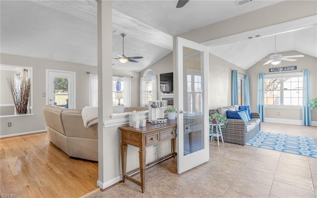 living room with ceiling fan, light hardwood / wood-style flooring, vaulted ceiling, and a wealth of natural light