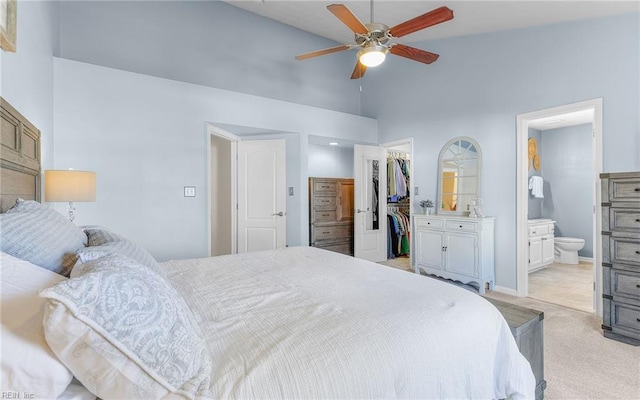 carpeted bedroom with ceiling fan, a walk in closet, a closet, and ensuite bath