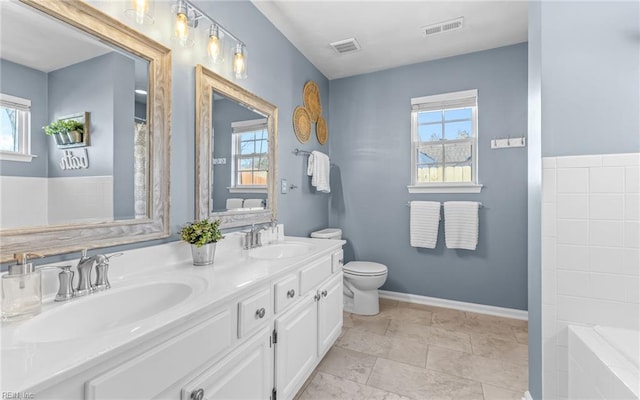 bathroom featuring toilet, walk in shower, a wealth of natural light, and vanity