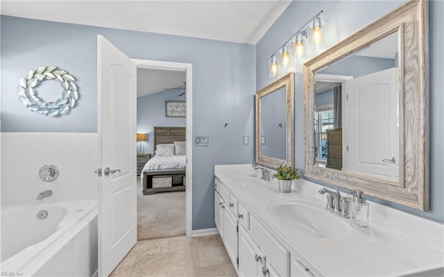 bathroom featuring vanity, tiled tub, and tile patterned flooring