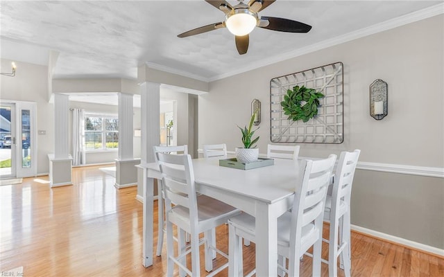 dining space with light hardwood / wood-style floors, crown molding, and ceiling fan with notable chandelier