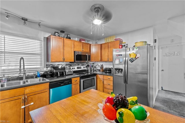 kitchen with sink, carpet flooring, backsplash, and appliances with stainless steel finishes