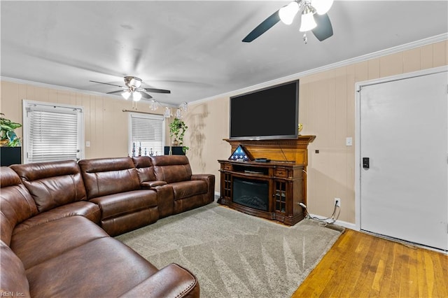 living room featuring hardwood / wood-style flooring, ceiling fan, and crown molding