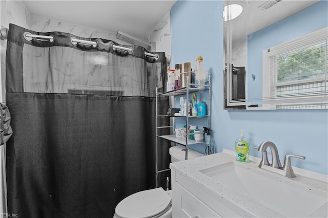 bathroom featuring toilet, a shower with shower curtain, and vanity