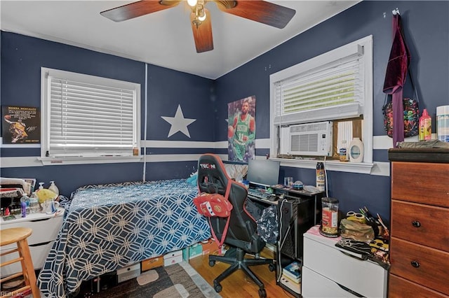 bedroom with cooling unit, wood-type flooring, and ceiling fan