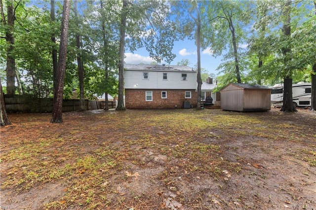 back of property featuring central AC unit and a shed