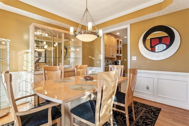 dining room featuring light wood-type flooring and crown molding