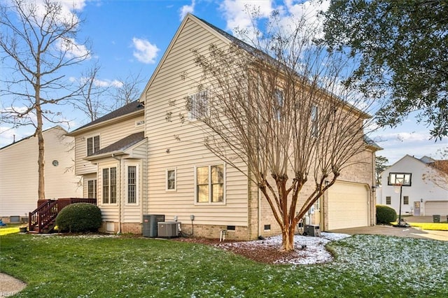 rear view of house with central air condition unit, a yard, and a garage